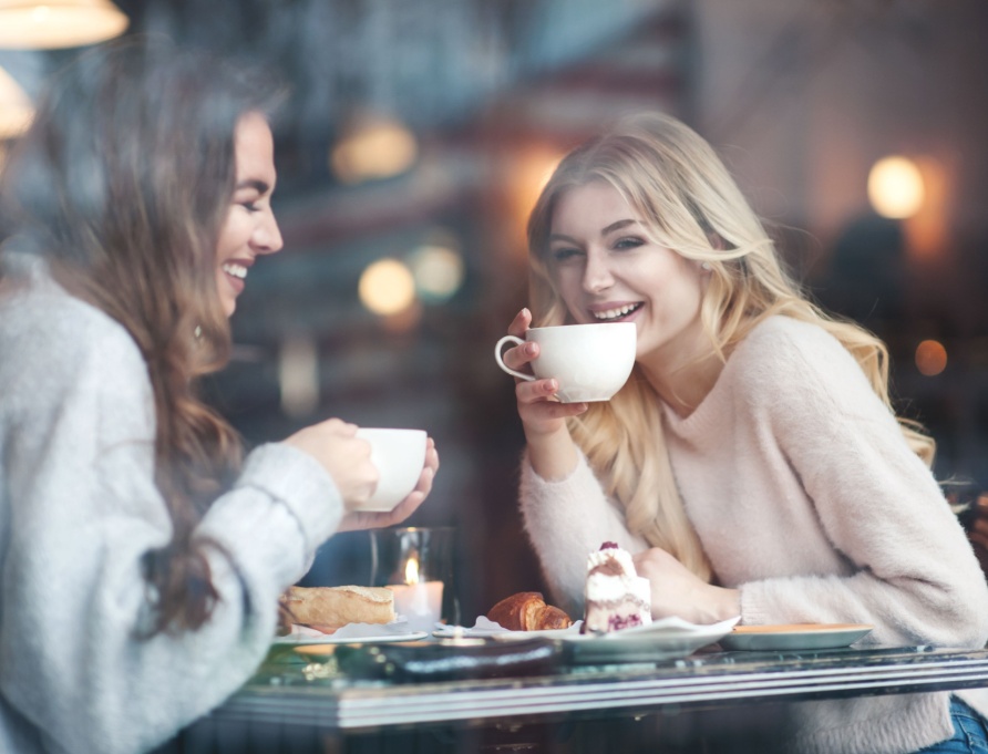 Two women talking and drinking coffee.