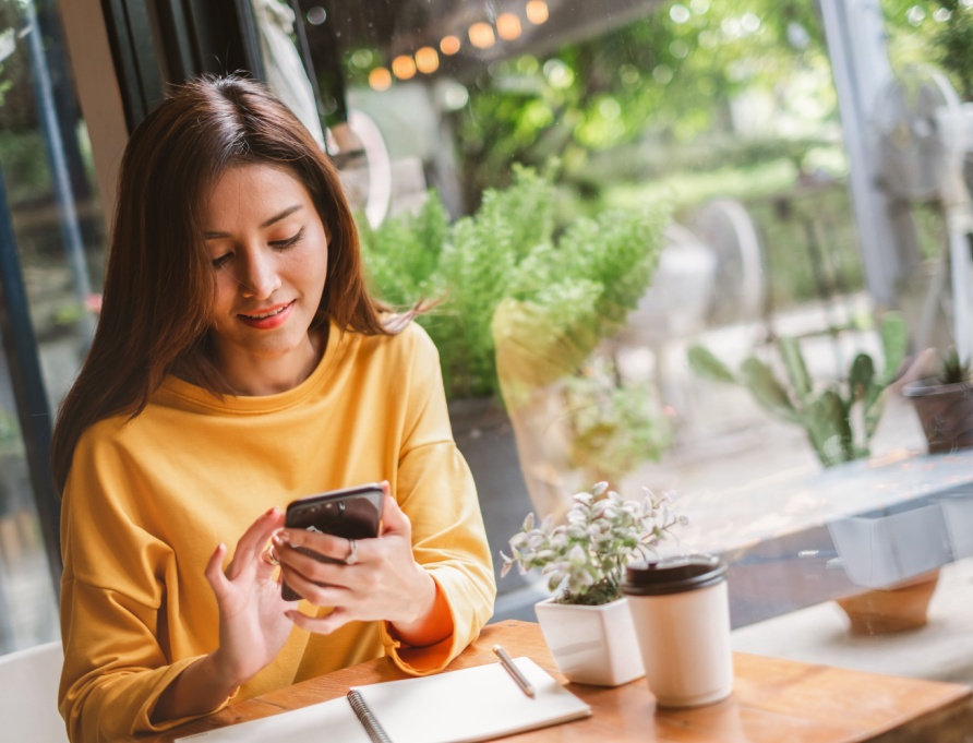 A woman using her phone in a café.