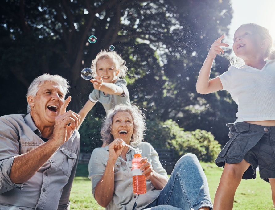 Grandparents blowing bubbles with their grandchildren.