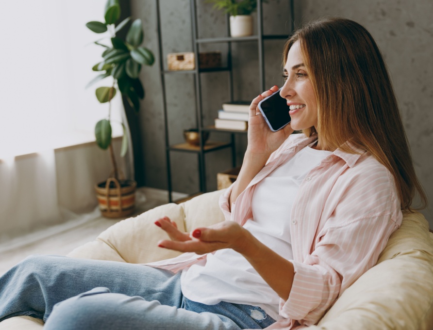 A woman talking on the phone at home.