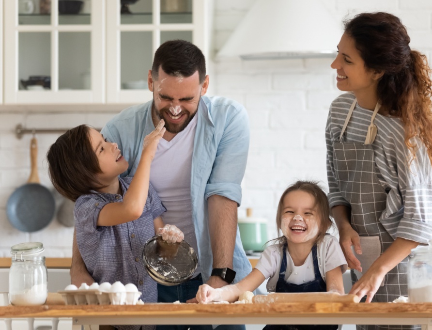 A family with young children baking together.