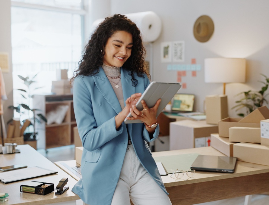 A female business owner using a tablet in an office.