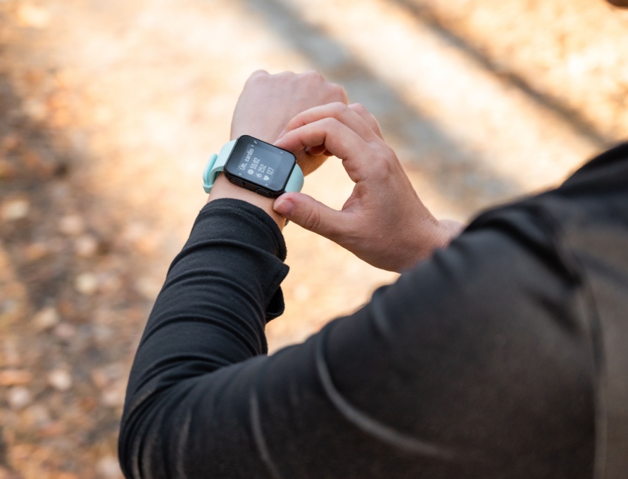 A runner looking at the time on their watch.