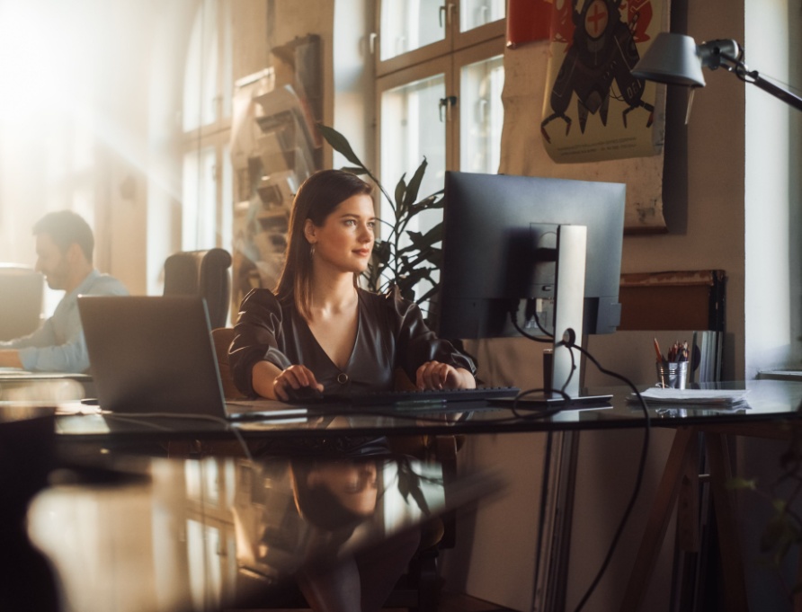 A woman using a computer in an office.